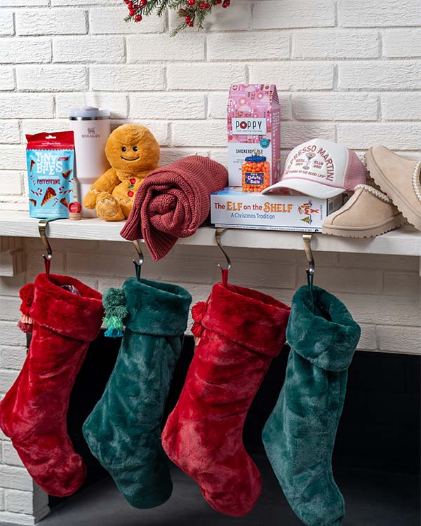 gifts sitting on a mantle and stockings hanging down from the fireplace